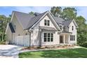 Side view of a two story home with a three car garage and manicured lawn at 6861 Ga Hwy 5, Douglasville, GA 30135