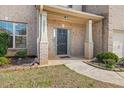 A covered front porch featuring the house number, a black door and green bushes at 3257 Alhambra Cir, Hampton, GA 30228