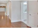 Open hallway featuring hardwood floors, white trim, and access to a bathroom with bright lighting at 3538 Serenade Nw Commons, Kennesaw, GA 30152