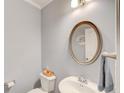 Cozy powder room featuring a pedestal sink, framed mirror, and modern lighting fixture at 401 Night Hawk Ct, Canton, GA 30114