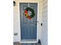 Close-up of a gray front door adorned with a wreath of flowers and greenery at 4940 Elm Brook Dr, Atlanta, GA 30349