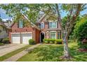 Lovely two-story brick home with a well-manicured lawn, mature trees, and a two-car garage at 1187 Druid Walk, Decatur, GA 30033