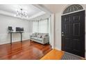 Bright living room featuring hardwood floors, a modern light fixture, and a stylish gray couch at 1187 Druid Walk, Decatur, GA 30033
