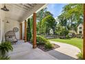 Inviting covered porch featuring stylish outdoor seating, wood columns, and a beautifully landscaped front yard at 230 Pebble Trl, Alpharetta, GA 30009