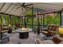 Cozy screened-in porch with stone fireplace and comfortable seating at 5155 Pine Branch Pt, Atlanta, GA 30338