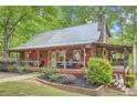 Exterior angle view featuring a covered porch, stone chimney and nicely landscaped flower beds at 5419 Tyree Rd, Winston, GA 30187