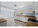 Bright kitchen with white cabinets, tile flooring, and ample counter space overlooking the eating area at 1229 Colony Cir, Marietta, GA 30068