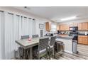 Open kitchen area with stainless appliances, bar seating, and dining table with modern chairs at 314 Meadows Ln, Canton, GA 30114