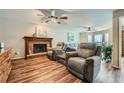 Cozy living room with a brick fireplace, wood floors, comfortable seating, and views from the back windows at 5170 Ridge Tarn, Acworth, GA 30102