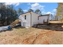 Exterior of the home showing the basement level and deck with staircases on a partially wooded lot at 4064 Post Rd, Winston, GA 30187