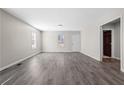 Bright living room with gray flooring, leading to front door and bedroom hallway at 4064 Post Rd, Winston, GA 30187