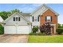 Charming two-story home featuring light blue siding, brick accents, a manicured lawn, and a two-car garage at 3471 Chastain Glen Ne Ln, Marietta, GA 30066