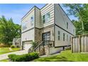Contemporary home with stone accents, landscaping, and a driveway, showcasing modern design and curb appeal at 2020 Bixby Se St, Atlanta, GA 30317