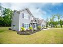Lovely two-story home with green lawn, black mulch flower beds, and ample sunshine at 445 Boulder Crest Trl, Villa Rica, GA 30180