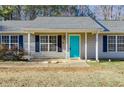 Close up of the exterior of the house with a bright blue door and dark shutters at 447 Wallace Way, Rockmart, GA 30153