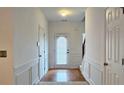 Bright foyer features hardwood floors, white wainscoting, and stairs leading to the upper level at 3479 Lake Forge Dr, Fairburn, GA 30213