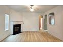 Spacious living room with a fireplace, neutral carpet, and open archways to other rooms at 3479 Lake Forge Dr, Fairburn, GA 30213