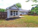 Back exterior of home with a sun room, fencing, and a wooden pergola in the backyard at 604 Lexington Way, Woodstock, GA 30189