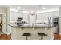 Modern kitchen featuring white cabinets, stainless steel appliances, and a convenient breakfast bar at 1055 Chelsey Way, Roswell, GA 30075