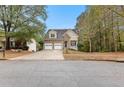 Inviting two-story home with stone accents, dual garage doors, and a neatly landscaped front yard at 100 Lantana Dr, Locust Grove, GA 30248