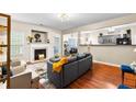 Open-concept living room featuring a fireplace, hardwood floors, and seamless flow to the modern kitchen at 100 Lantana Dr, Locust Grove, GA 30248