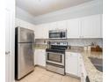 Well-lit kitchen featuring granite countertops and stainless steel appliances and tile flooring at 1850 Cotillion Dr # 4306, Dunwoody, GA 30338