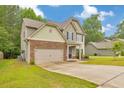 Charming two-story home features a stone-accented facade, well-manicured lawn, and attached two car garage at 2534 Grayton Loop, Villa Rica, GA 30180