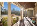 Spacious covered porch featuring wood decking, views of nature, and charming light fixtures at 121 Harmony Oaks Trl, Canton, GA 30115