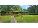 Charming single-story home featuring a brick exterior and a spacious front yard with mature trees and a stone pathway at 2886 The Fontainebleau Sw, Atlanta, GA 30331