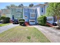 Charming multi-colored townhomes with front lawn, brick steps, and driveways for off street parking at 3716 Meeting St, Duluth, GA 30096