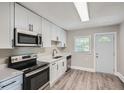 Modern kitchen featuring white cabinets, stainless steel appliances, and a bright window at 1002 Ira Sw St, Atlanta, GA 30310