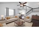 Bright living room with high ceilings, ceiling fan, plush sofas, dark wood floors, and a view into the dining room at 1468 Briarwood Ne Rd # 2003, Atlanta, GA 30319