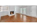 Cozy living room with hardwood floors, a fireplace, and access to an outdoor deck at 4440 Coventry Ne Ct, Roswell, GA 30075