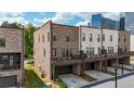 Rear exterior view of townhouses featuring a deck with garage parking and a well-manicured lawn at 1626 Aldworth Se Pl, Atlanta, GA 30339