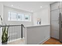Hallway features hardwood floors, black railings, and plenty of natural light from the large window at 230 New St # 2102, Decatur, GA 30030