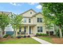 Charming two-story home with a well-manicured lawn, front porch seating, and beautiful landscaping at 3219 Colchester St, Douglasville, GA 30135