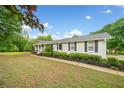 Inviting single-Gathering home with beautiful shrubbery along the walkway and well-maintained lawn at 3415 Trickum Rd, Woodstock, GA 30188