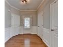Well-lit foyer features hardwood floors, white trim, and multiple doors for seamless transitions into other rooms at 2505 Thackery Ct, Cumming, GA 30041