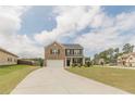 Inviting two-story home featuring a brick facade, well-manicured lawn, and a spacious driveway leading to a two-car garage at 3868 Sweet Iris Cir, Loganville, GA 30052