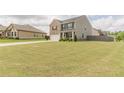 Well-maintained two-story home with a spacious front yard and a long driveway leading to a two-car garage at 3868 Sweet Iris Cir, Loganville, GA 30052