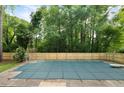 Backyard features a large, covered pool, surrounded by a new wooden fence and lush trees at 102 River Oaks Dr, Woodstock, GA 30188
