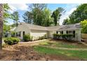 Attractive home featuring tidy landscaping, neutral siding, black shutters, and well-maintained green lawn at 102 River Oaks Dr, Woodstock, GA 30188