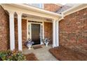 Inviting front porch with flower pots, pillars, and a welcome mat at 2269 Howell Farms Nw Trl, Acworth, GA 30101