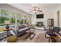 Bright living room featuring a fireplace, large windows, comfortable seating, and a ceiling fan at 2623 Riggs Dr, Atlanta, GA 30344