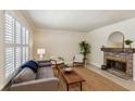 Cozy living room featuring large windows, neutral colors, a fireplace, and hardwood floors at 104 Verlaine Nw Pl, Atlanta, GA 30327