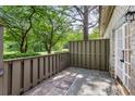Private patio with stone floor, wood fence, and access to the lush green backyard at 104 Verlaine Nw Pl, Atlanta, GA 30327