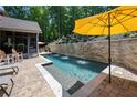 Inviting backyard pool area with stone accents, perfect for relaxation and outdoor enjoyment at 112 Pebblebrooke Run, Canton, GA 30115