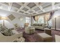 Elegant living room featuring a coffered ceiling, stylish furniture, and large windows for natural light at 4891 Tarry Post Ln, Suwanee, GA 30024