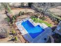 Aerial view of a sparkling in-ground pool with ample patio space and lush landscaping at 4891 Tarry Post Ln, Suwanee, GA 30024