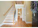 Inviting foyer with hardwood floors, staircase, and view of the kitchen at 5020 Huntshire Sw Ln, Lilburn, GA 30047